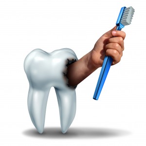 Brushing teeth concept as a human tooth with a cavity as a hand emerging out holding a generic toothbrush or tooth brush as a dental health care symbol for oral hygiene to avoid cavities on teeth.
